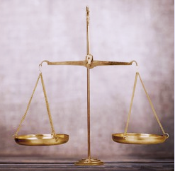 A gold balance scale with uneven, empty pans stands on a neutral surface against a blurred background.